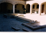Patio porticado sobre pilastas de piedra maciza y ladrillo rustico con pavimento empedrado